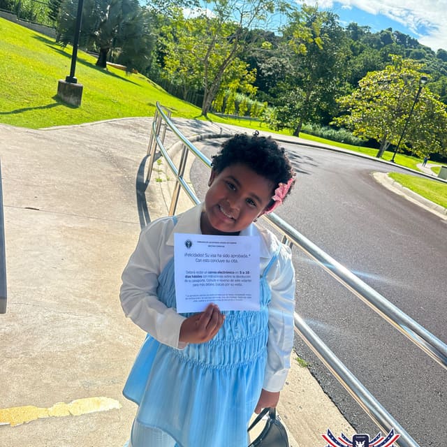 Niña clienta de TRAMITAPA sosteniendo su carta de visa aprobada